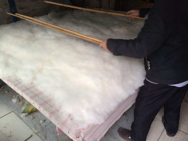农民把新收的棉花加工做成棉被